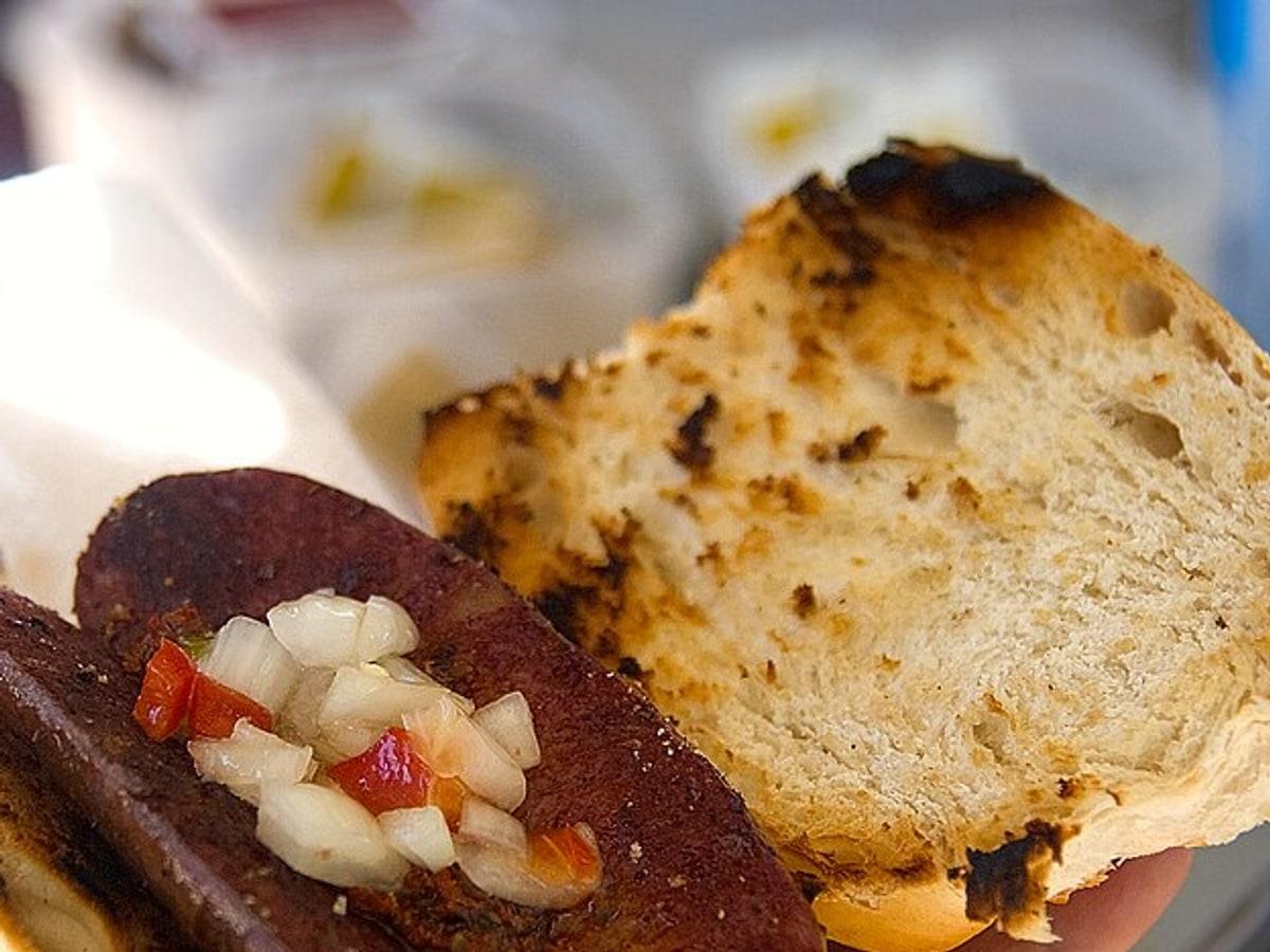 Grilled sausage sandwich in crusty bread with chopped onion relish.