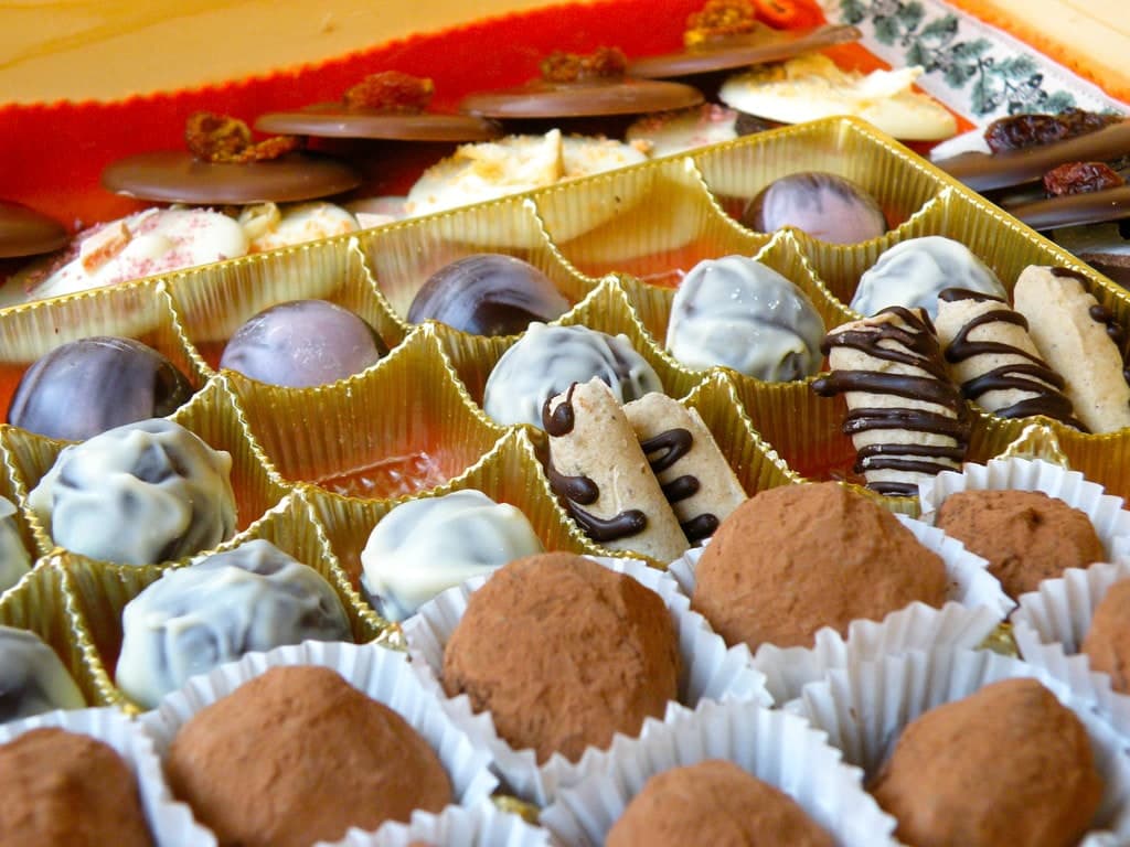 Verschiedene gefüllte Pralinen in einer Schachtel angeordnet.