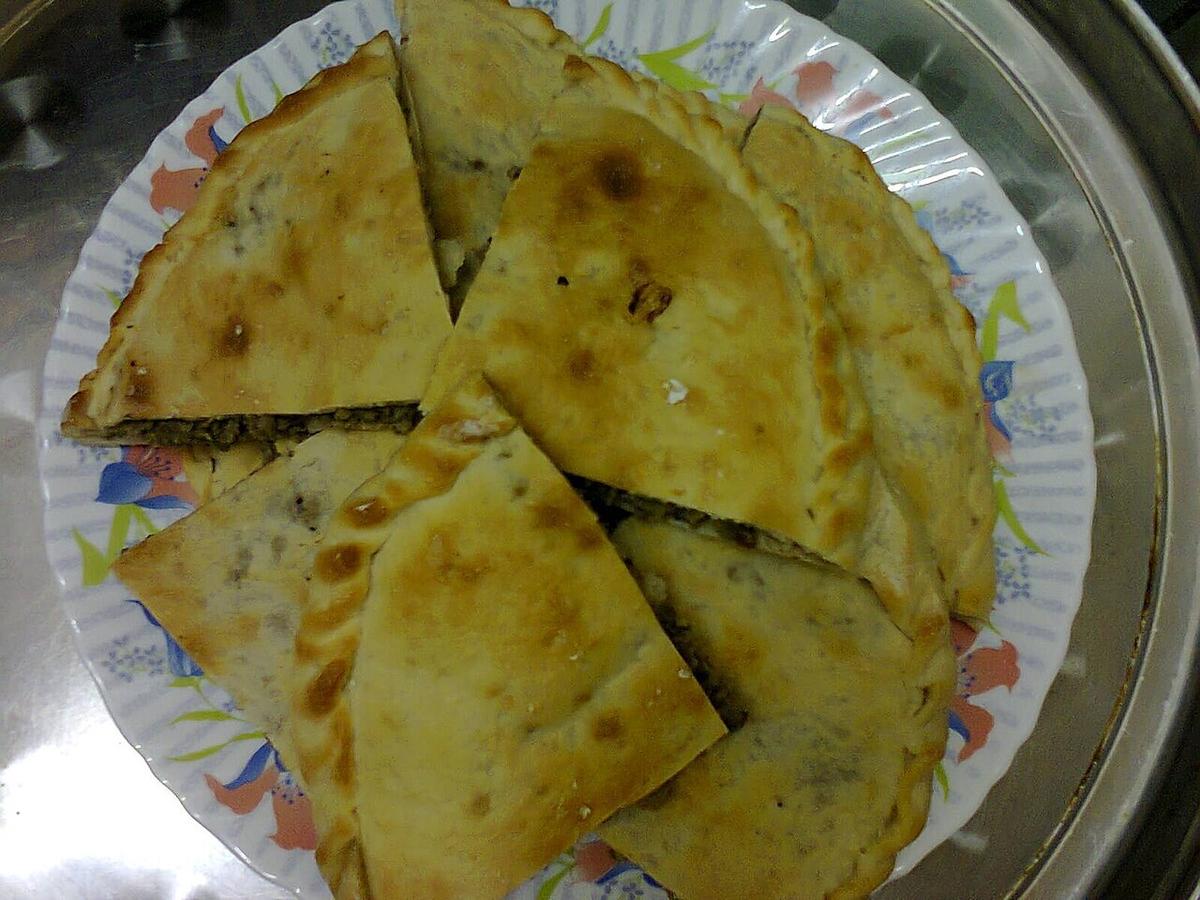 Triángulos de pan plano relleno en una bandeja de metal.