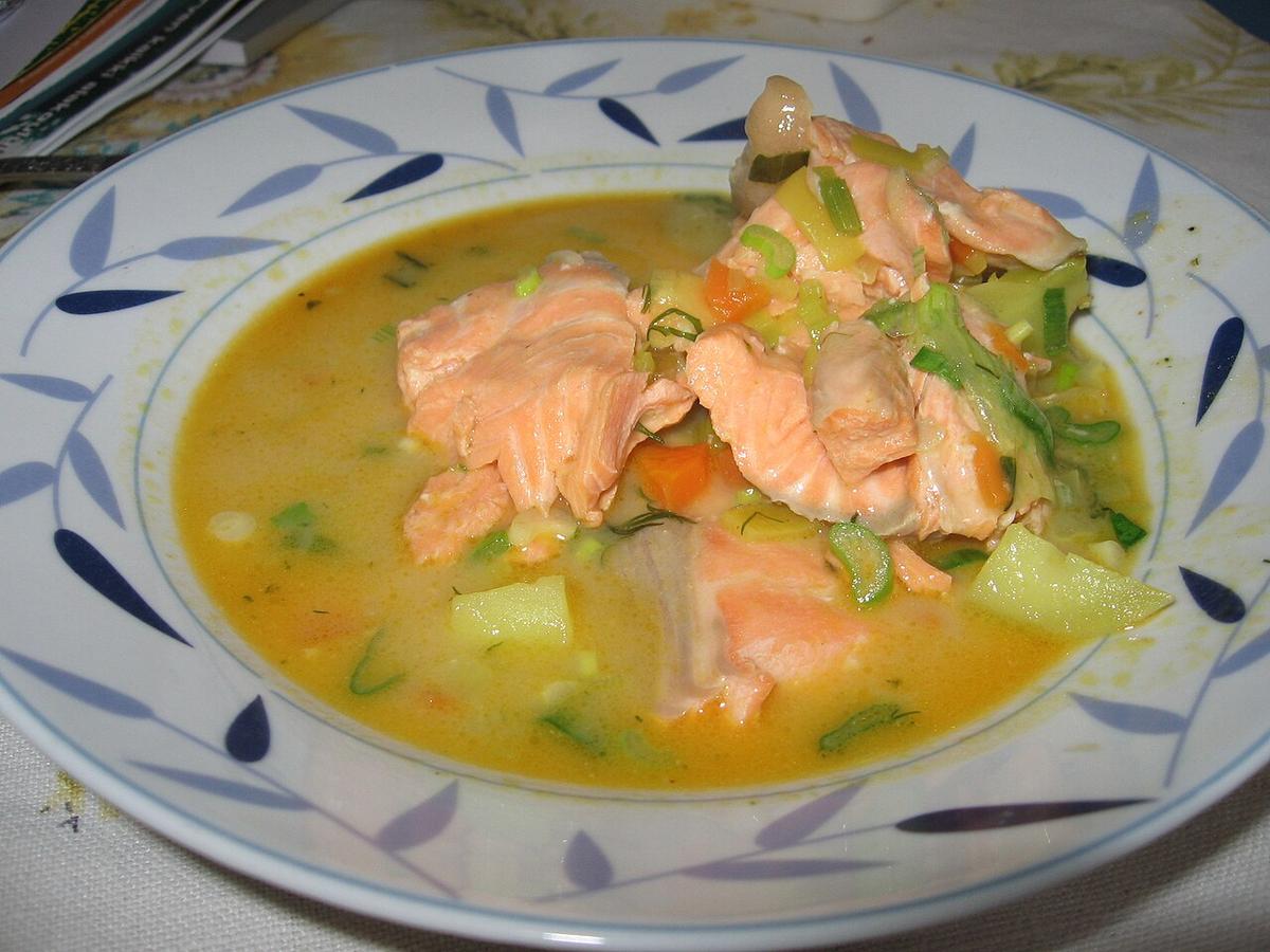 Creamy salmon soup with potato chunks and dill in a bowl.