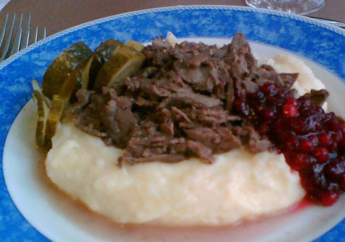 Sautéed reindeer on mashed potatoes with lingonberries and pickles.