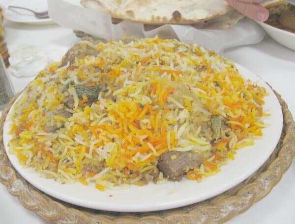 Plate of long-grain rice layered with mutton pieces and saffron-colored grains.