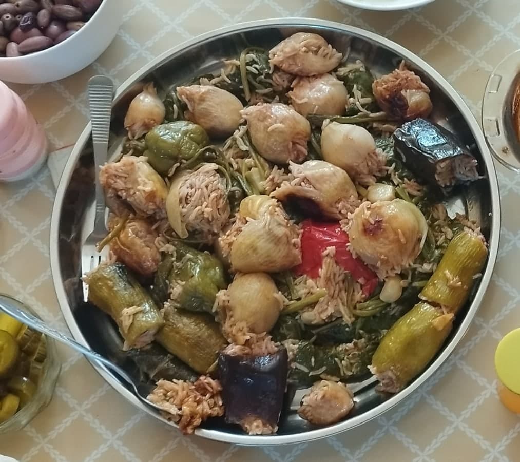 Round platter filled with stuffed grape leaves and vegetables.