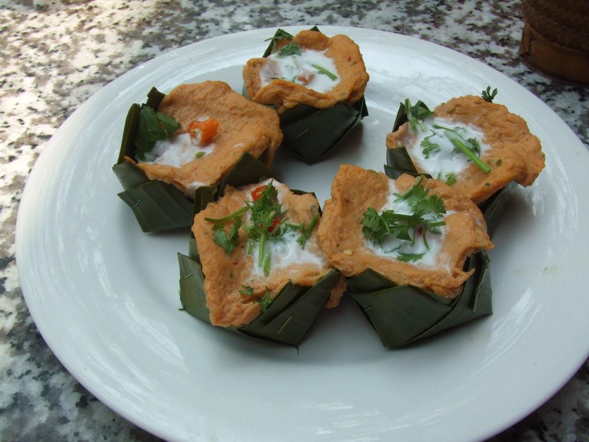 Steamed fish portions in banana leaf cups on a plate.