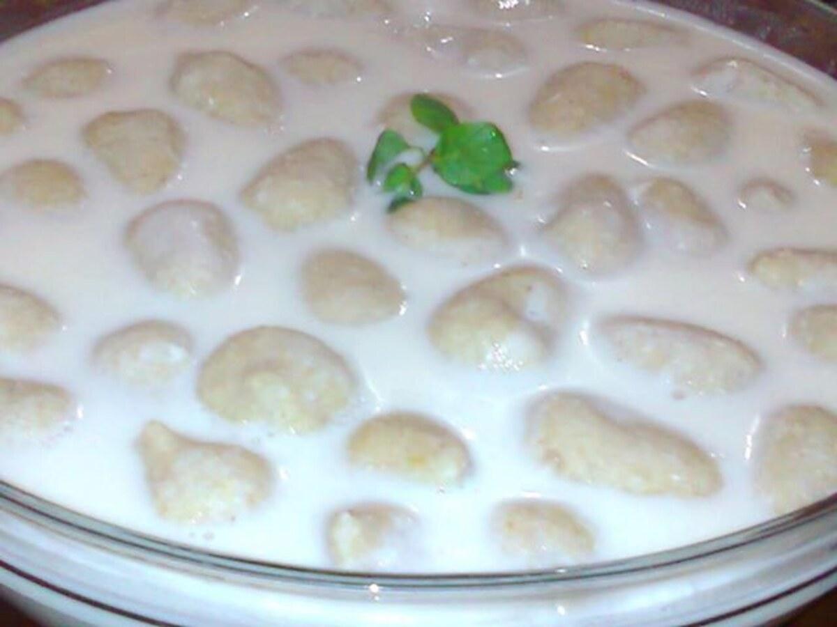 Kleine Kibbeh-Knödel in cremiger weißer Joghurtsauce mit kleinem grünem Kräutergarnitur.