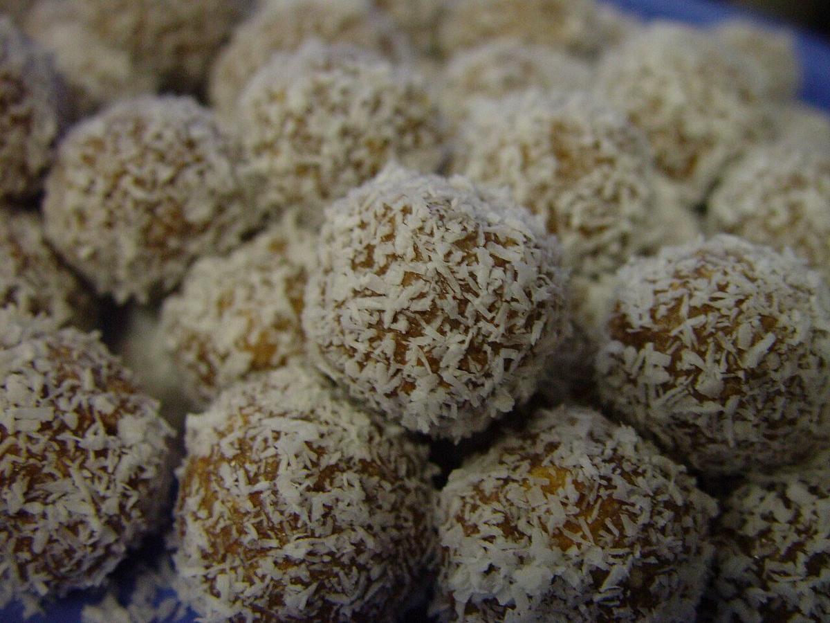 Boules de riz enrobées de noix de coco regroupées sur une assiette.