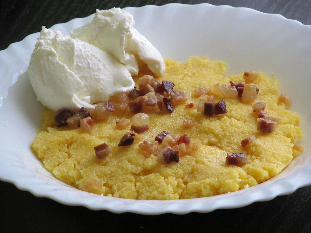 Bol de bouillie de maïs crémeuse jaune avec de petits morceaux dorés sur le dessus.