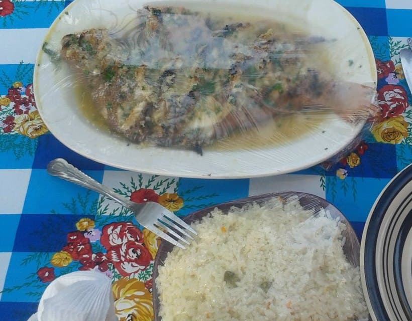 Poisson grillé et bouillie de maïs blanche ferme servie dans des assiettes.