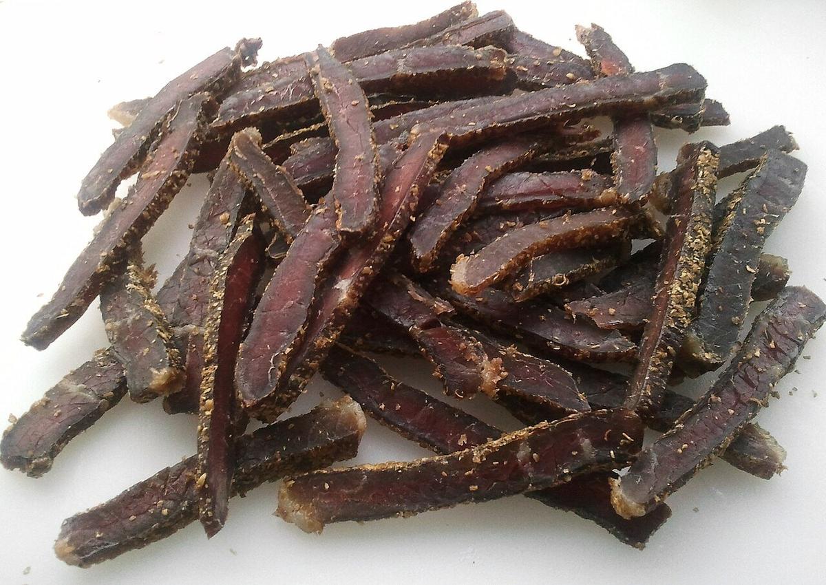 كومة من شرائح اللحم المجفف المملح على خلفية بيضاء.