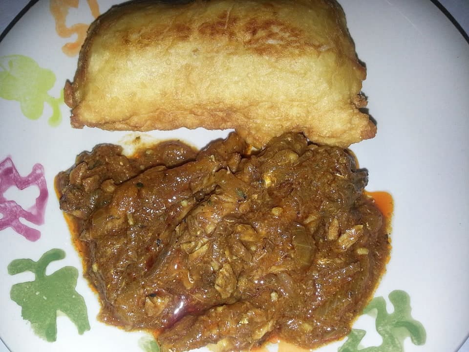 Pan frito servido junto a un montículo de carne molida con salsa en un plato decorado.
