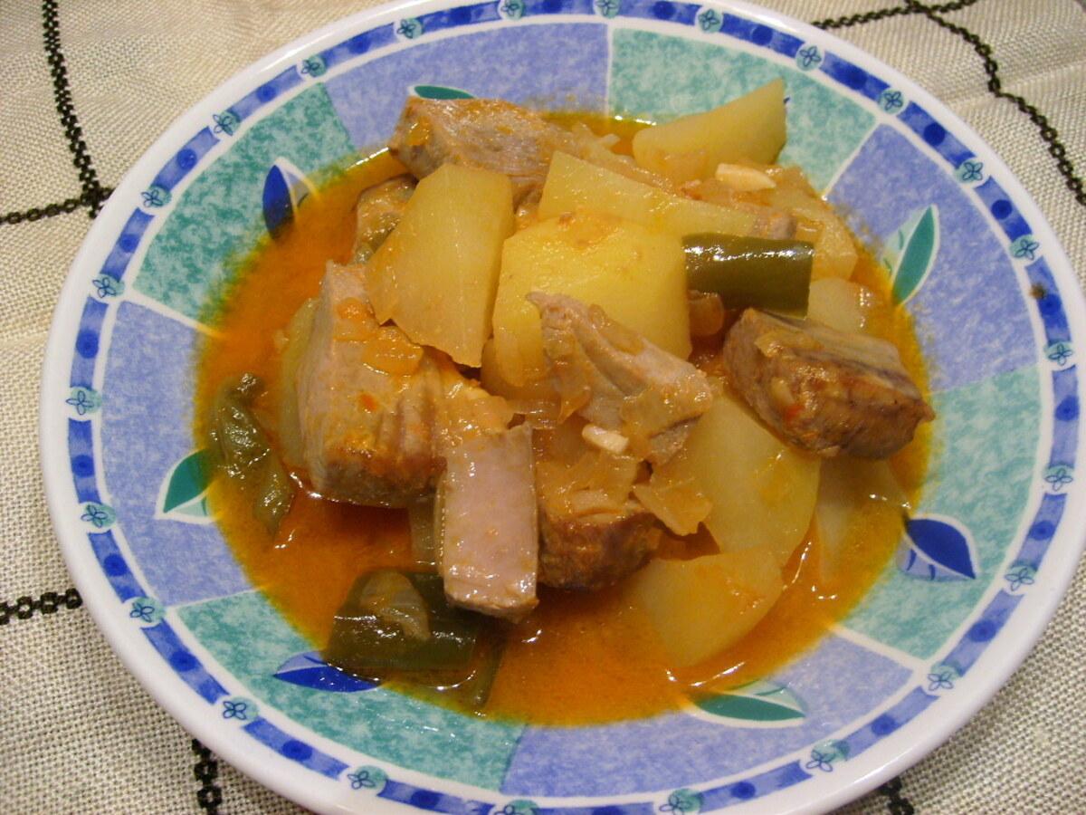 一盘带有辣椒的金枪鱼土豆炖菜，汤汁呈红色。