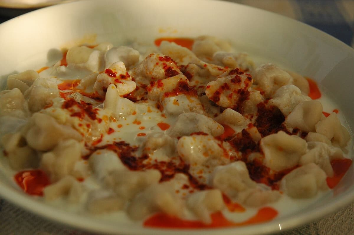 Small filled dumplings in yogurt sauce with red pepper butter and dried herbs.