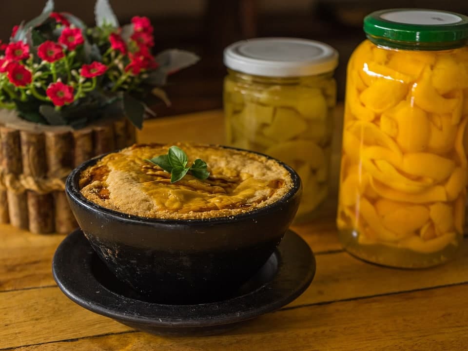 Golden savory pie in a small black baking dish on a wooden table.