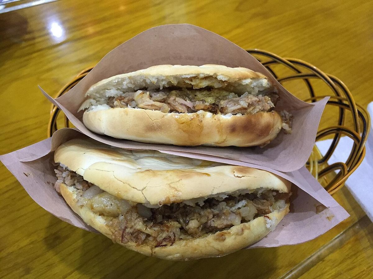 평평한 빵에 다진 조림 고기를 넣은 모습.