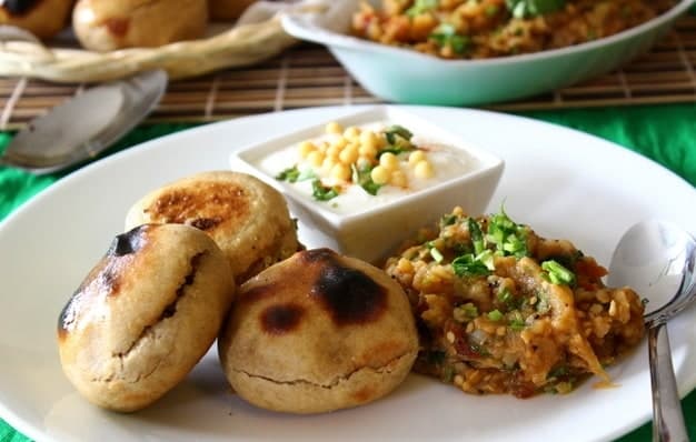Geröstete runde Teigbällchen mit zerdrücktem Gemüse als Beilage.