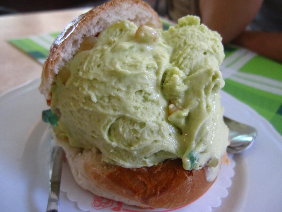Pale green pistachio frozen dessert scoops in a cup.