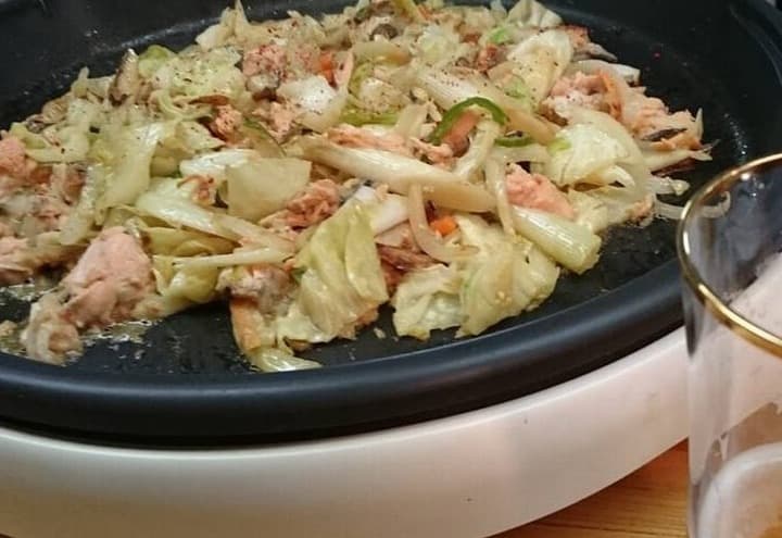काले गर्म तवे पर मिक्स मिसो सॉस के साथ सैल्मन और सब्ज़ियाँ।