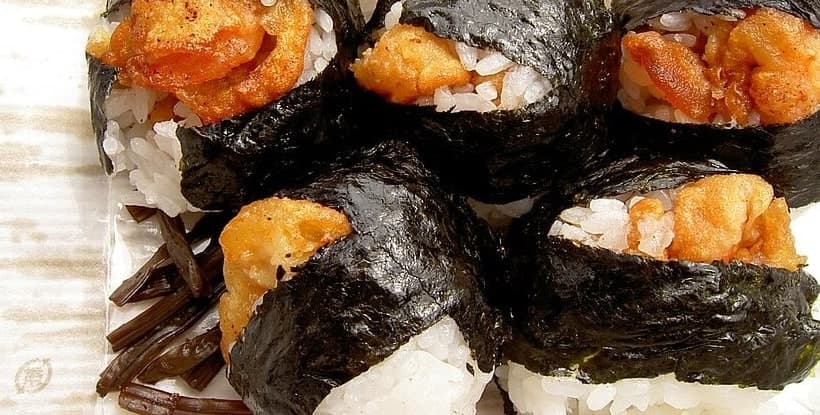 Nahaufnahme von Reisbällchen in Nori, gefüllt mit Garnelen-Tempura.