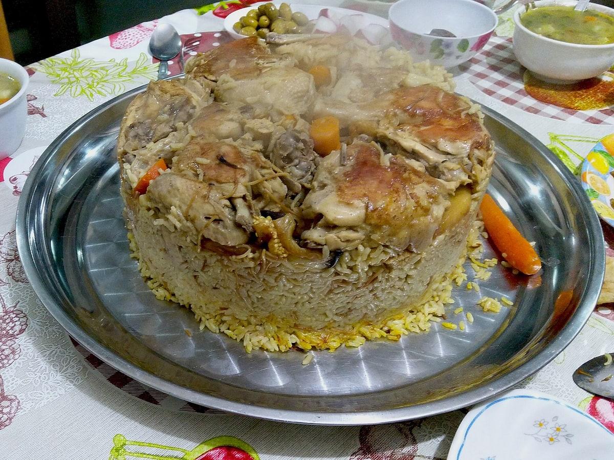 Layered mound of rice, meat, and vegetables on a serving tray.