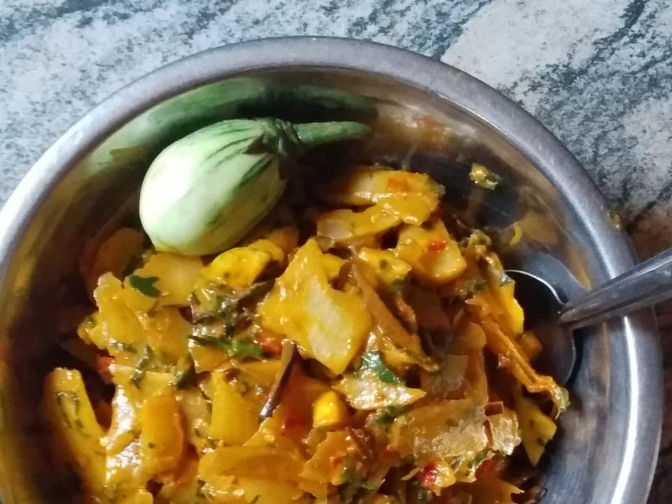 سلطة الكسافا المبشورة في وعاء معدني مع صلصة البيض وزيت النخيل.