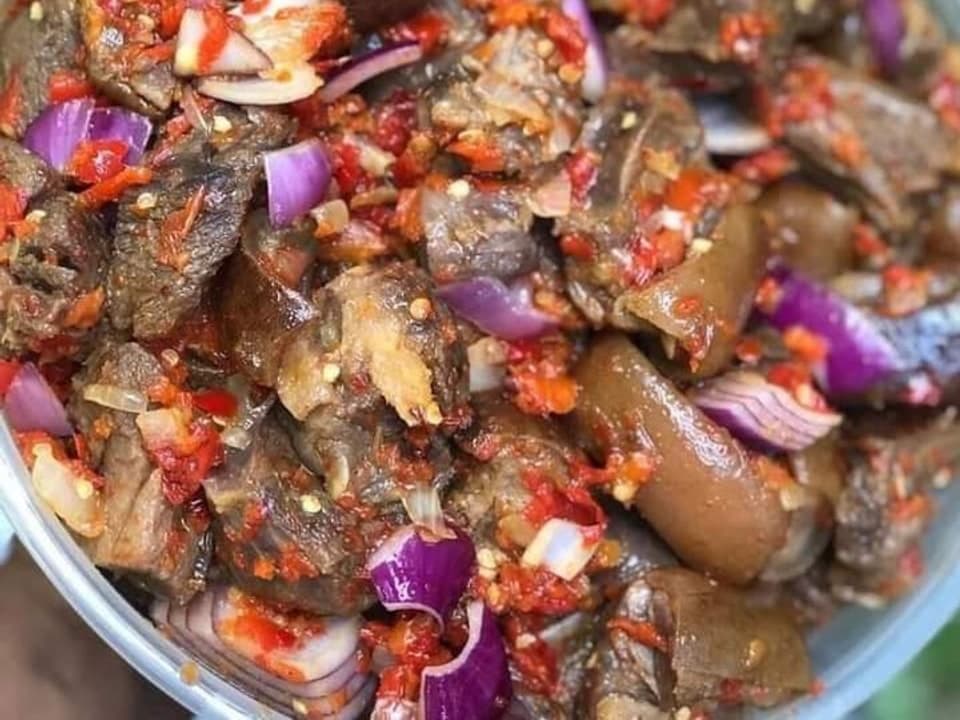 Bol de viande de chèvre hachée épicée avec oignon et morceaux de piment.