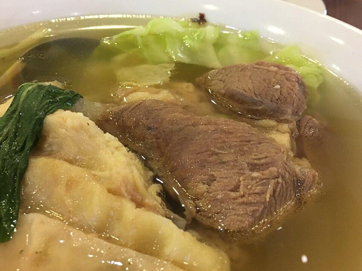 Sup daging sapi bening dengan sumsum, kol, dan sayuran hijau.