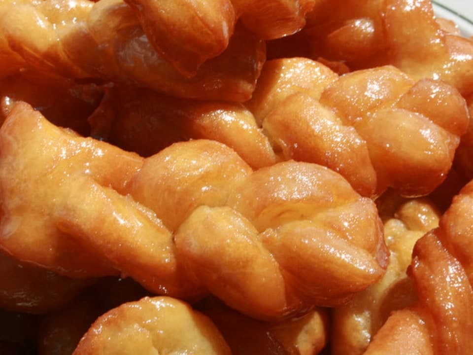 Glänzend goldene, geflochtene Teigstücke dicht aufgetürmt.