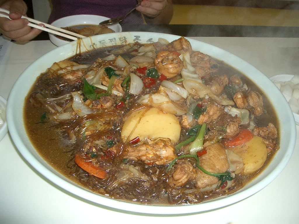 Soy-braised chicken and glass noodles on a large plate.