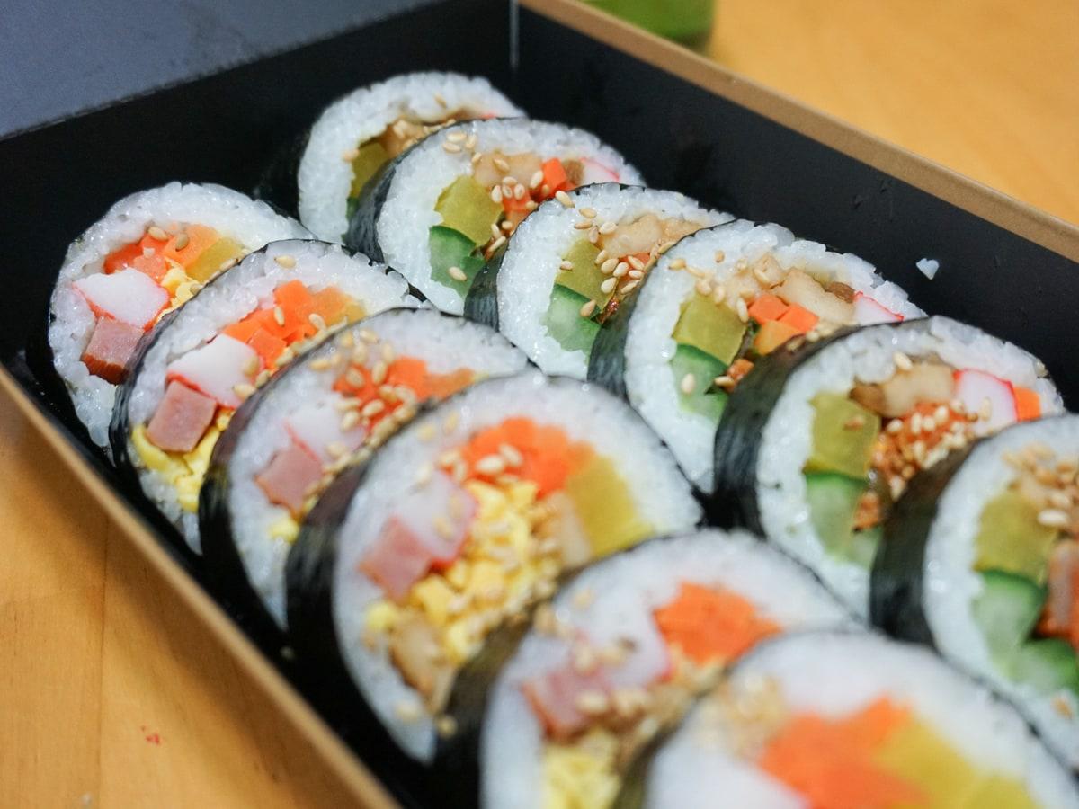 다채로운 야채와 달걀 속을 채운 얇게 썬 김밥 롤입니다.