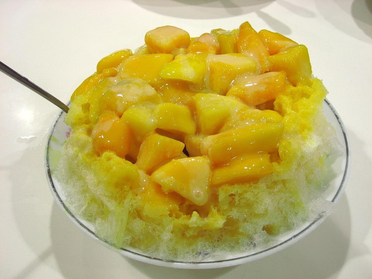 Mangowürfel auf gehobeltem Eis in einer Glasschale.