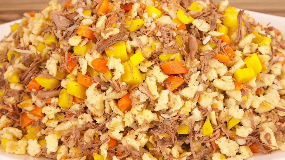 Primer plano de pan picado, carne desmenuzada y verduras en una fuente.