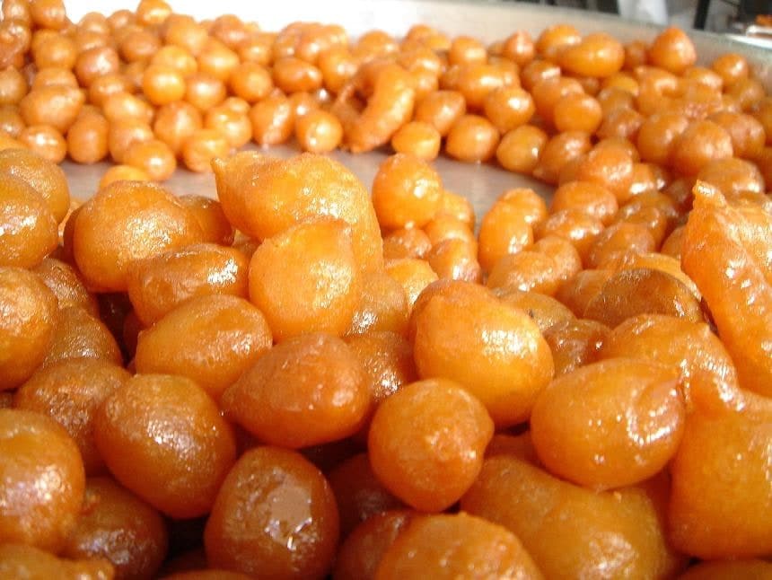 Glossy golden fried dough balls clustered together.