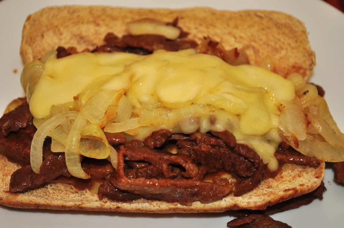 Long pain rempli de bœuf tranché, d'oignons et de fromage fondu.