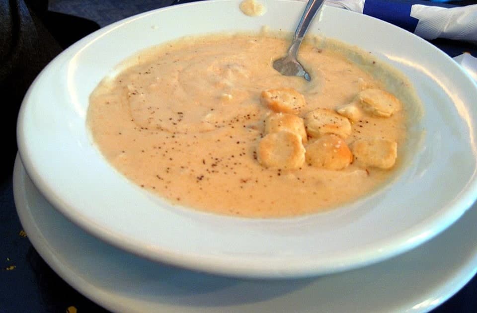 Cremige Krabbensuppe in einer flachen weißen Schüssel mit Crackern.